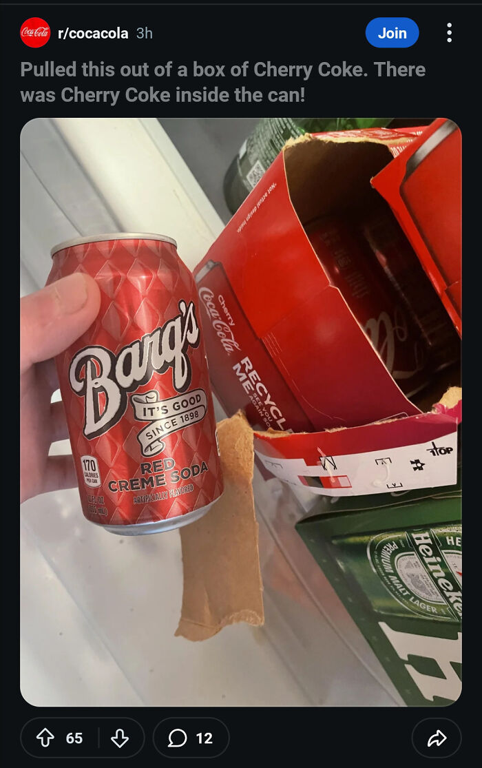 Hand holding Barq's Red Creme Soda can found inside a Cherry Coke box