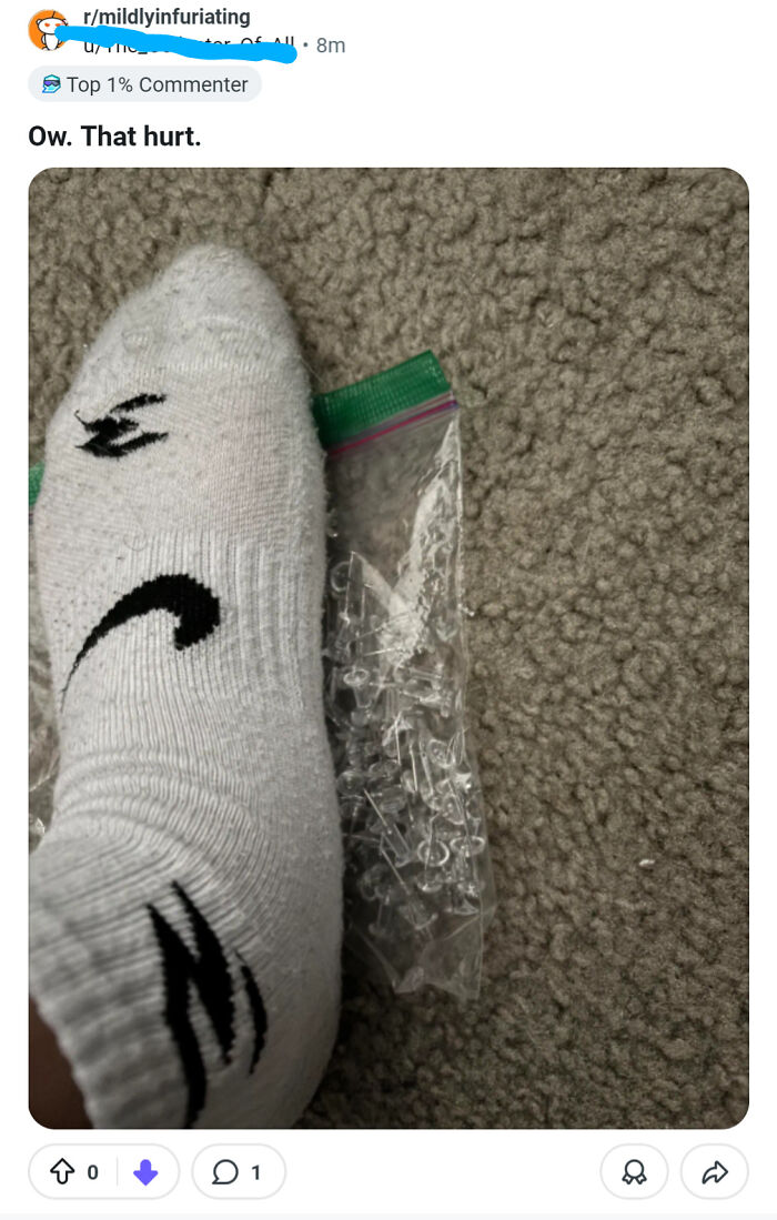Foot in sock near broken plastic push pins on carpet