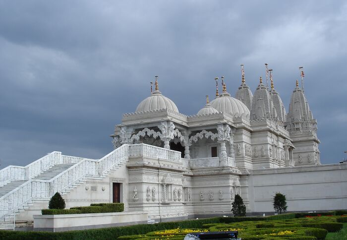 Intricate white marble temple architecture under cloudy sky