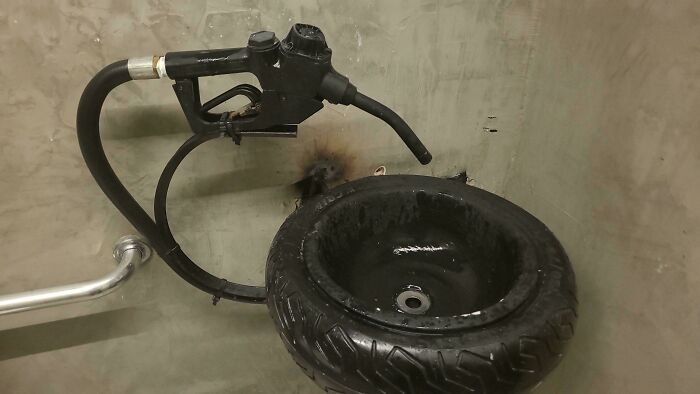 Bathroom sink made from a tire with a gas pump nozzle faucet in unusual bathroom design