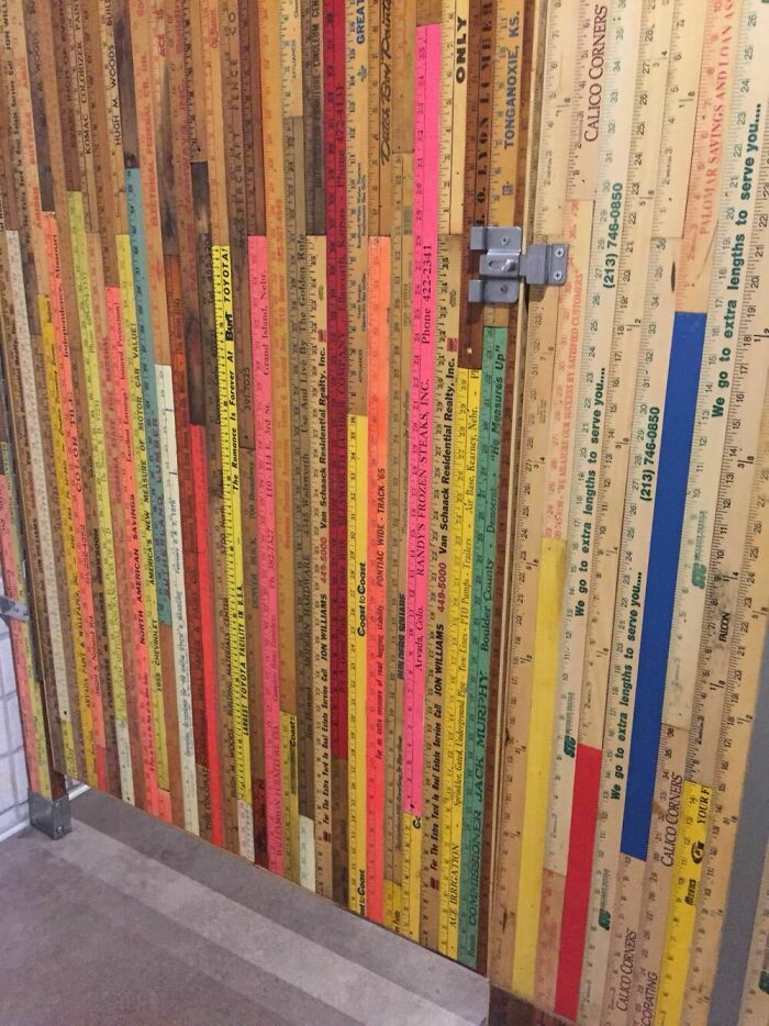 Bathroom stall door covered with colorful vintage rulers