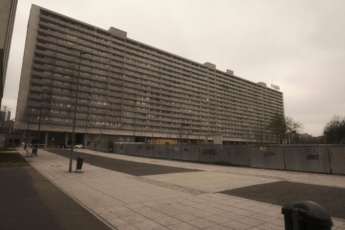 Wide shot of large gray urban apartment building under overcast sky