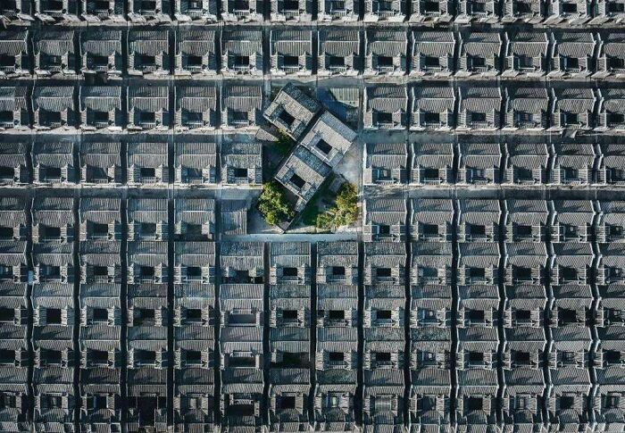 Aerial view of repetitive tiled rooftops in an eerie urban setting