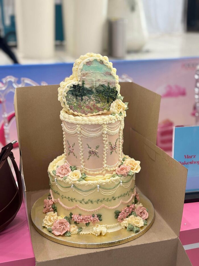 Decorated tiered cake with edible floral painting and pastel buttercream