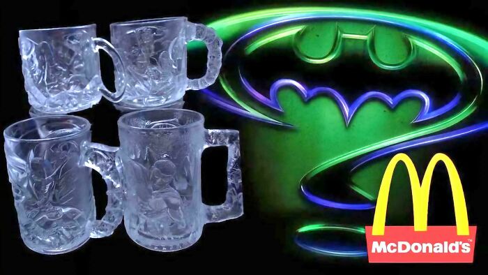 Four clear Batman Forever McDonald's mugs, a popular 90s kids collectible, with a glowing Batman logo.