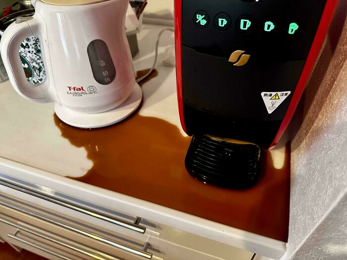 Kitchen coffee machine spill causing a large brown liquid mess on counter