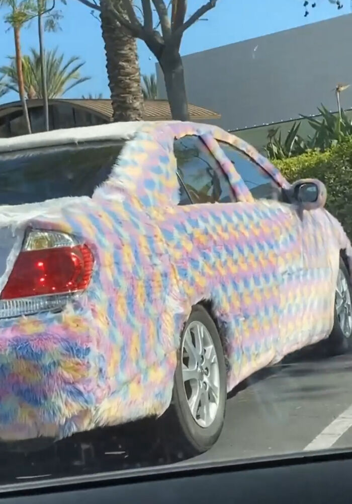 Car covered fully with fluffy colorful fabric showing cleaning oversight in vehicle design