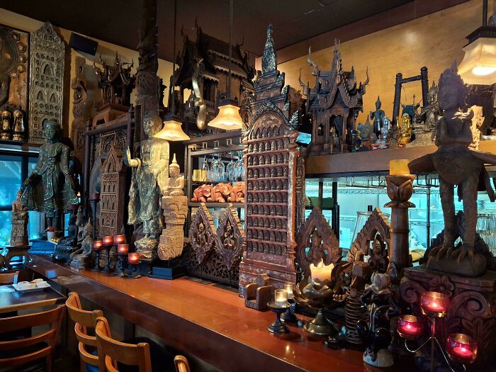 Restaurant interior filled with intricate wooden sculptures highlighting cleaning neglect