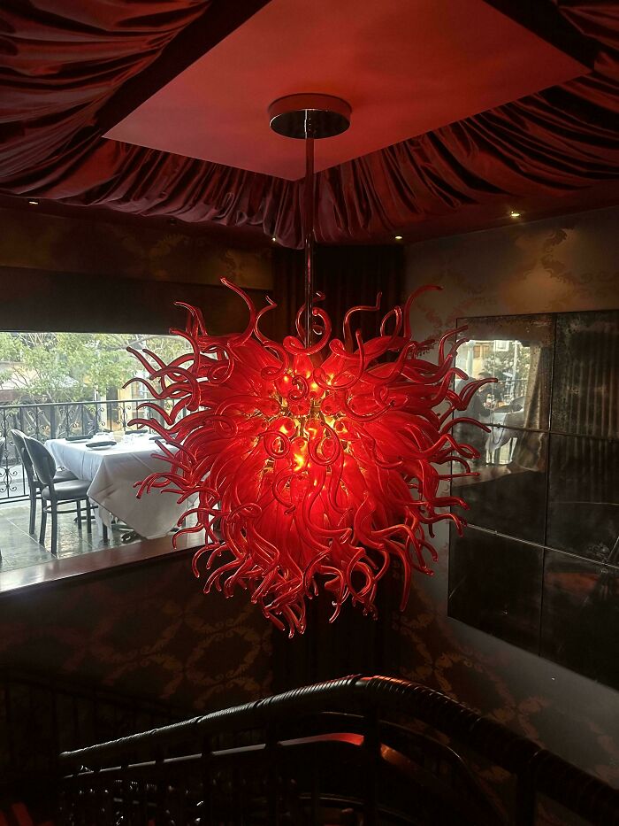 Red chandelier with fiery abstract glass design in dining area
