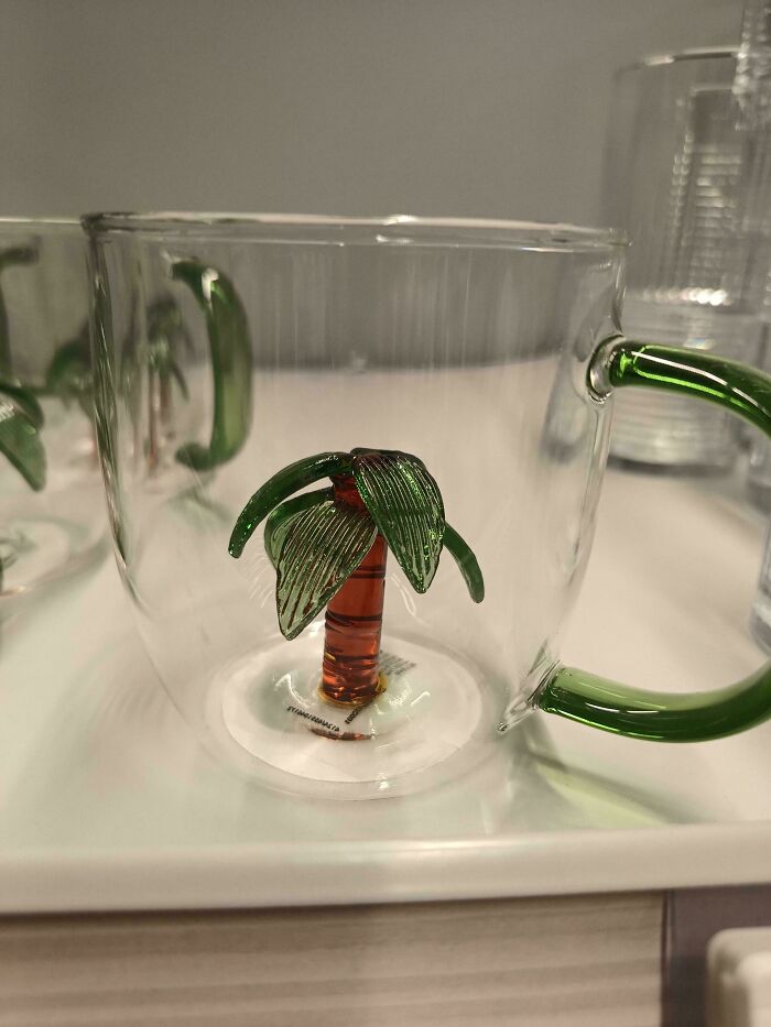Glass cup with palm tree figure embedded inside