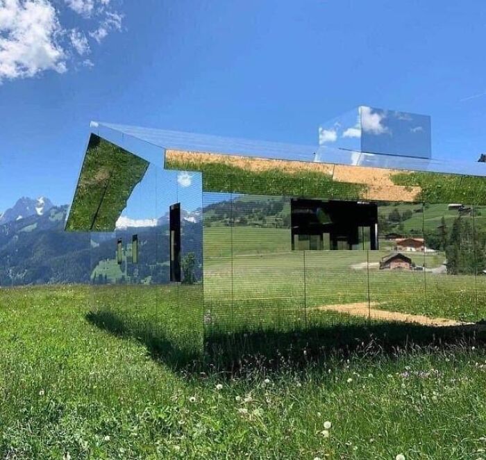 Mirror-clad house reflecting green grass and sky
