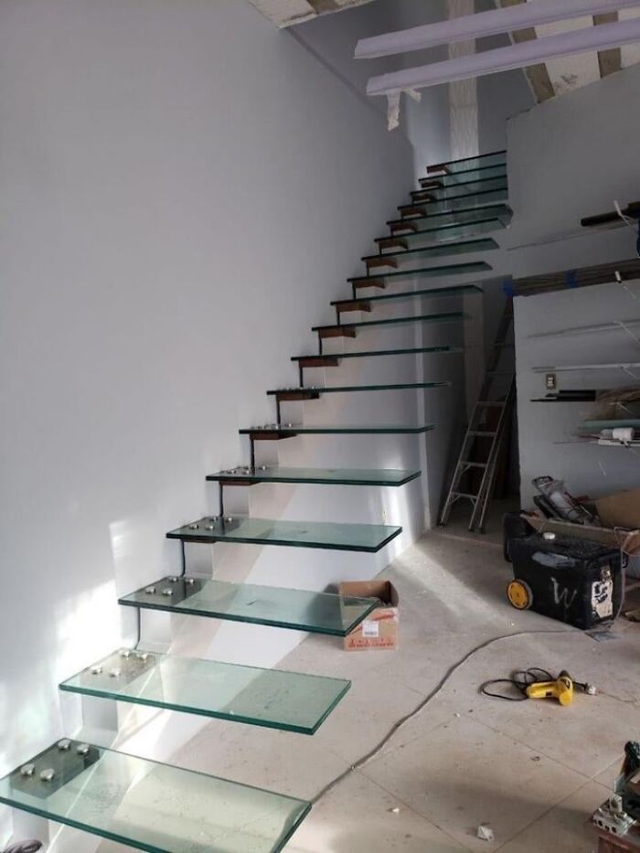 Glass stair treads floating with minimal support in under construction area