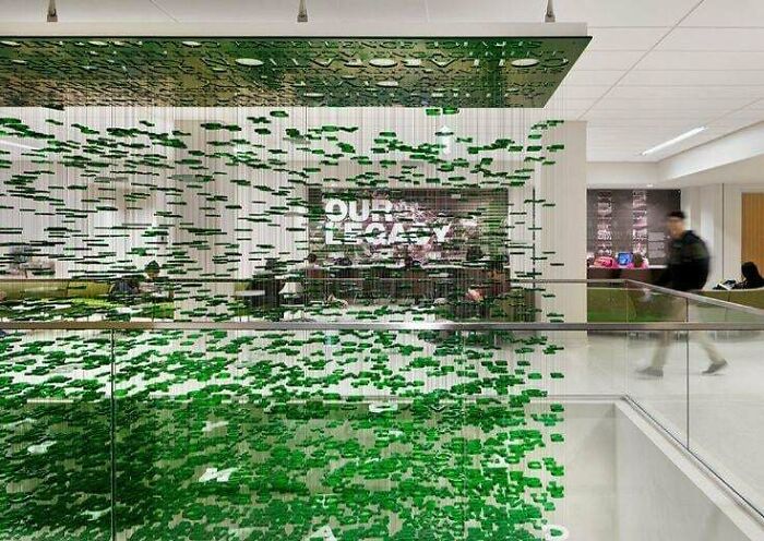 Modern office interior with suspended green decorative panel installation