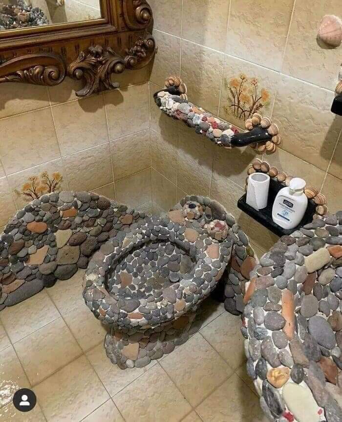 Unusual bathroom with stone-covered toilet and handrail design