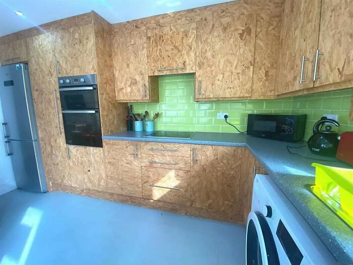 Kitchen with plywood cabinets and green tile backsplash design