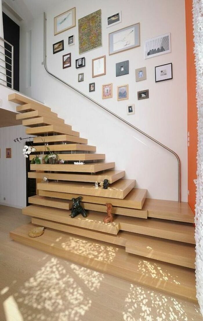Floating wooden staircase with integrated shelves and decorative items