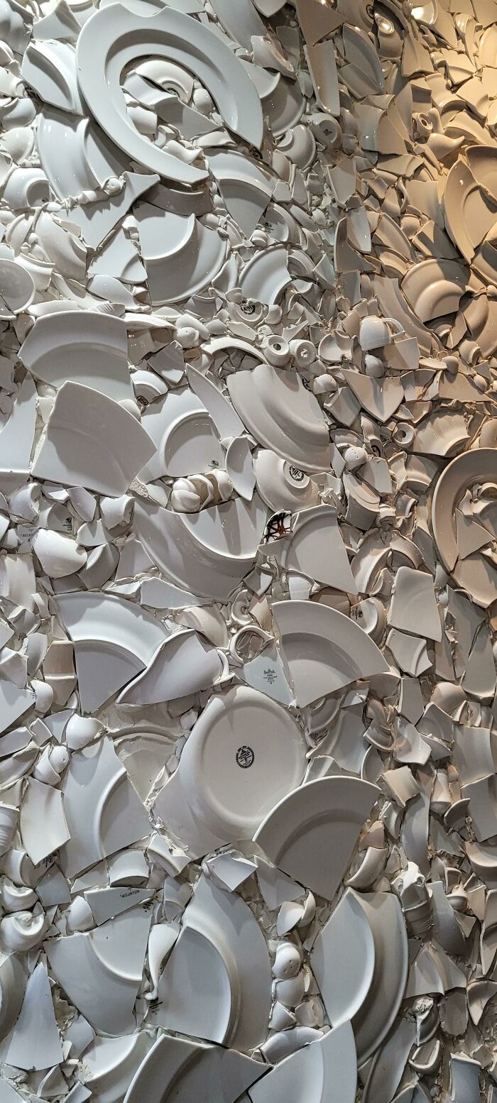 Wall covered entirely with shattered white ceramic plates