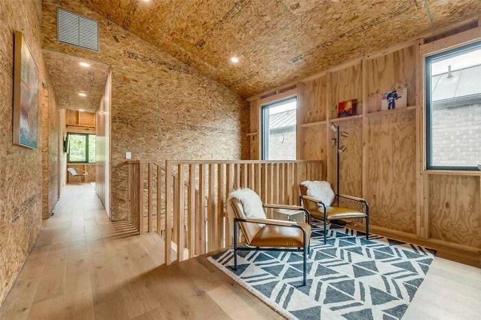 Cozy wooden interior room with plywood walls, ceiling, and minimal furniture