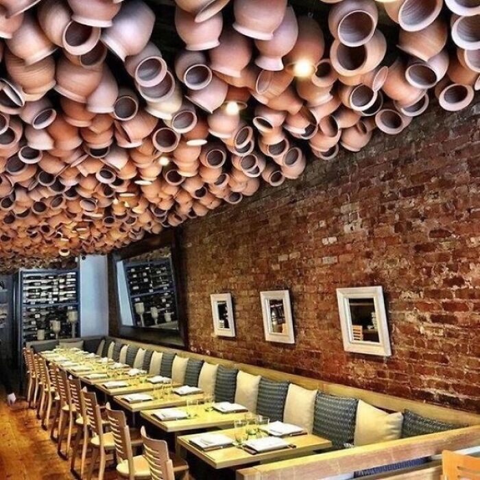 Restaurant interior with ceiling covered in clay pots creating unusual ceiling decor