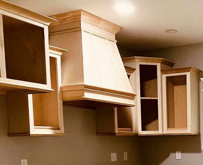 Partially finished kitchen cabinets and hood showing poor design or installation