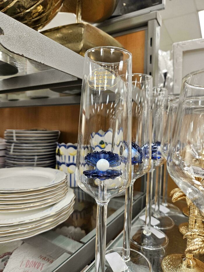 Decorative champagne flutes with dusty blue flower designs on shelves