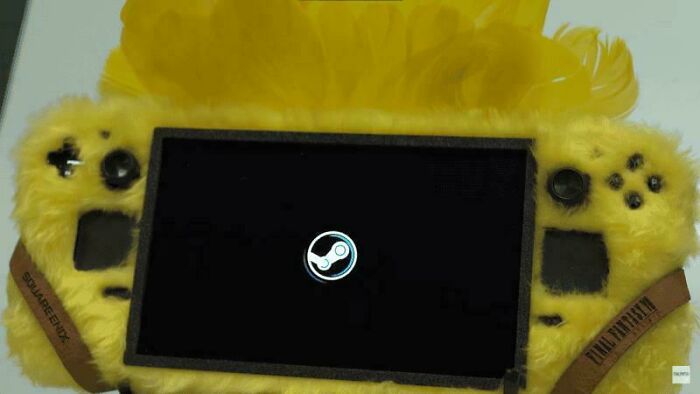 Yellow furry game console with dust and Steam logo on screen