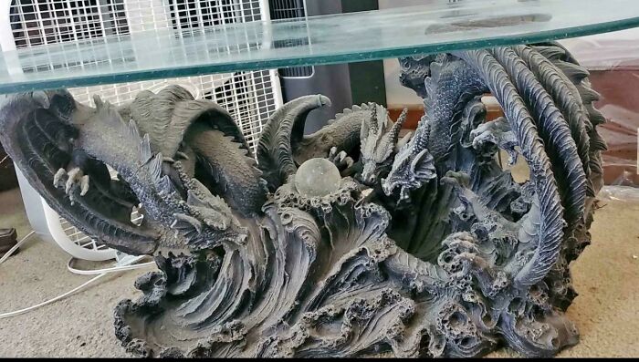 Table with dragon sculpture base showing elaborate and unclean design elements