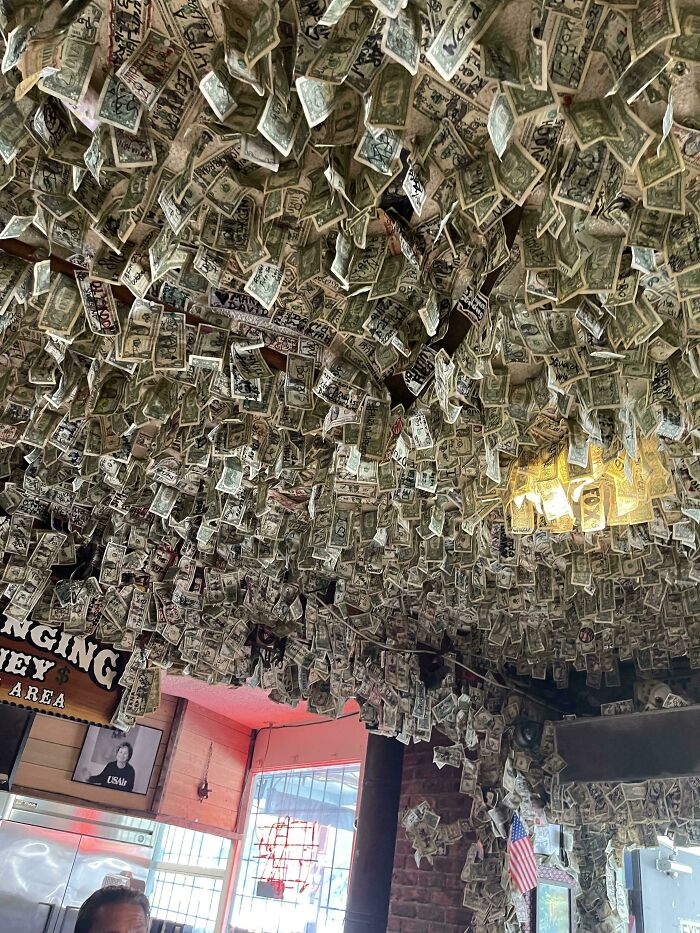 Ceiling covered in dollar bills with marked designs showing unclean installation