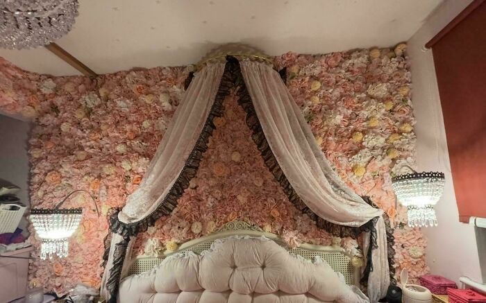 Floral wall behind bed decorated with fabric canopy shows intricate interior design