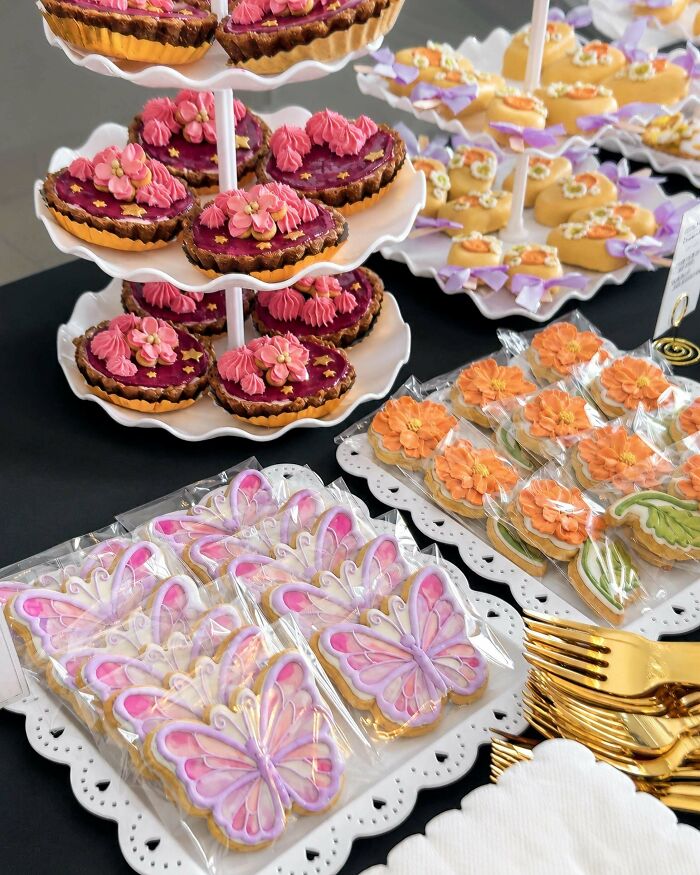 Flower and butterfly decorated cookies on display stand