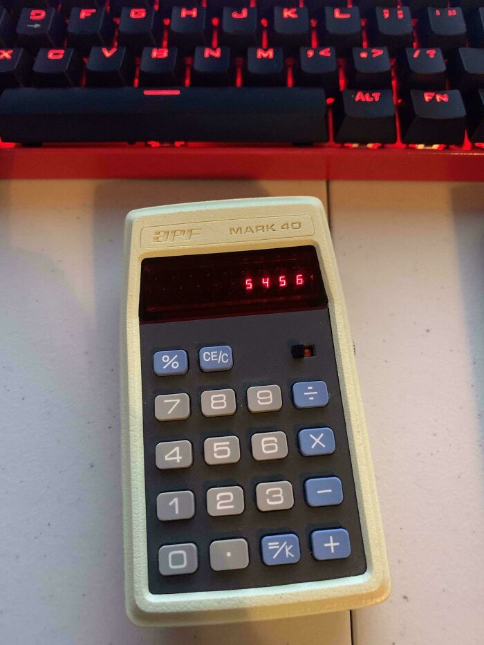 A beige DPF Mark 40 retro calculator with a red LED display showing 5456, against a modern red-lit keyboard. A true time machine into older times.