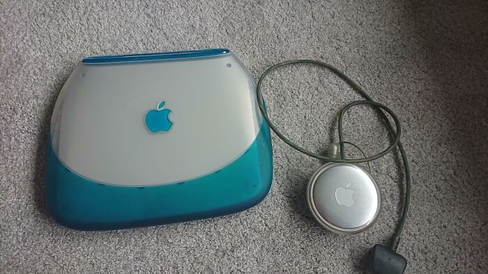 A teal and white retro iMac G4 computer and a silver Apple iPod Shuffle, evoking older times.