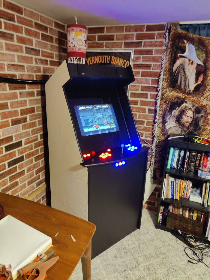 This retro pic shows a custom arcade machine against a brick wall, bringing us back to older times.