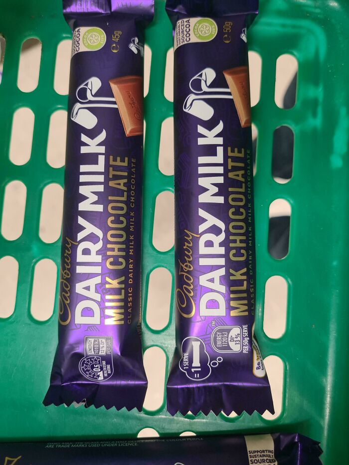 Two Cadbury Dairy Milk chocolate bars in a green basket, showcasing interesting posts for an Aussie.