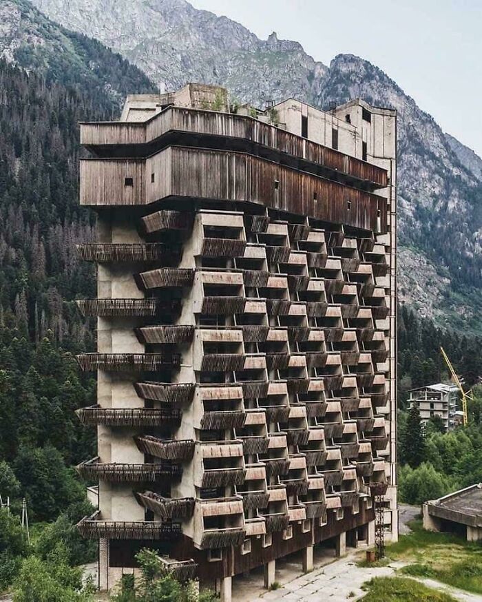 Brutalist urban hell building with balconies in mountain setting