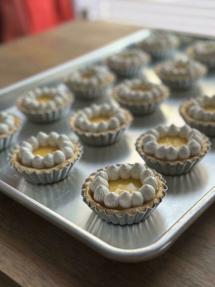 Mini tarts with cream topping on a baking tray dessert