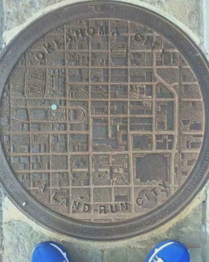 Manhole cover designed as a detailed city map for creative everyday things improvement