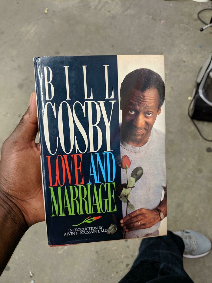 Hand holding absurd secondhand Bill Cosby book titled Love and Marriage