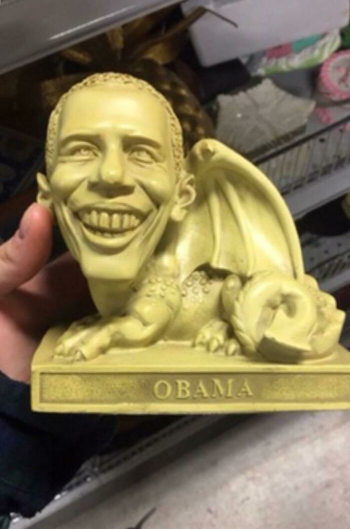 Yellowish sculpture combining a dragon body and a smiling Obama head