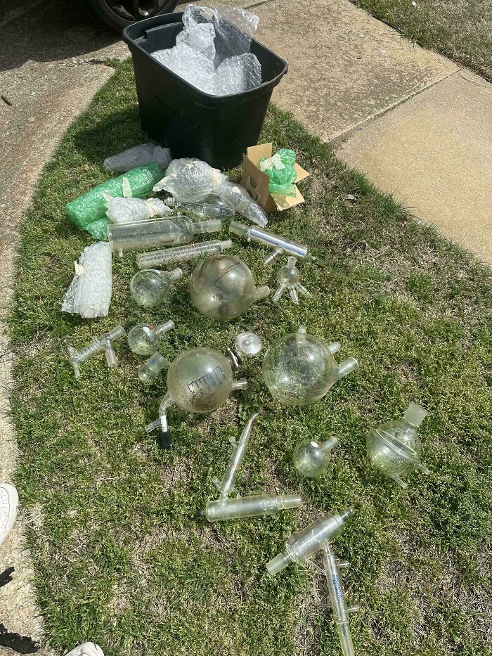 Collection of strange secondhand scientific glassware laid out on grass