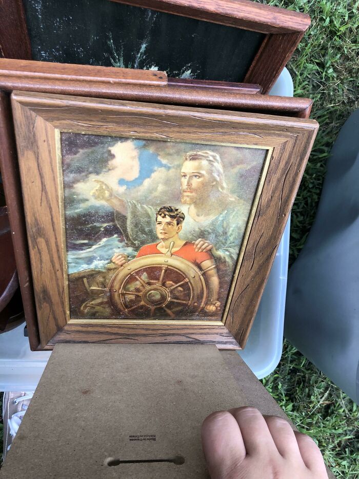 Framed religious artwork of Jesus guiding a boy at the helm