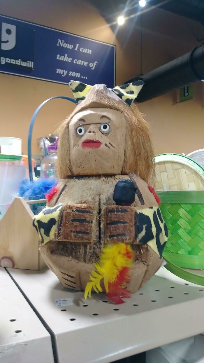 Absurd secondhand wooden figurine with leopard print and feather details in thrift store