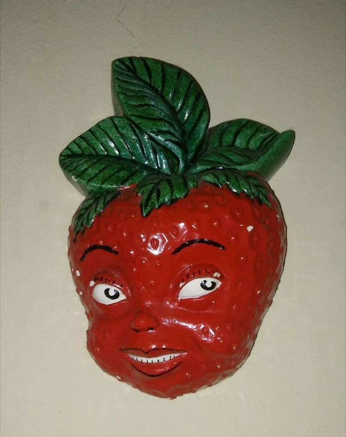Secondhand wall decoration of a strawberry with a cartoonish human face