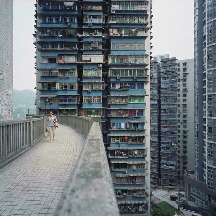 Dense urban hell residential towers with a pedestrian on the bridge