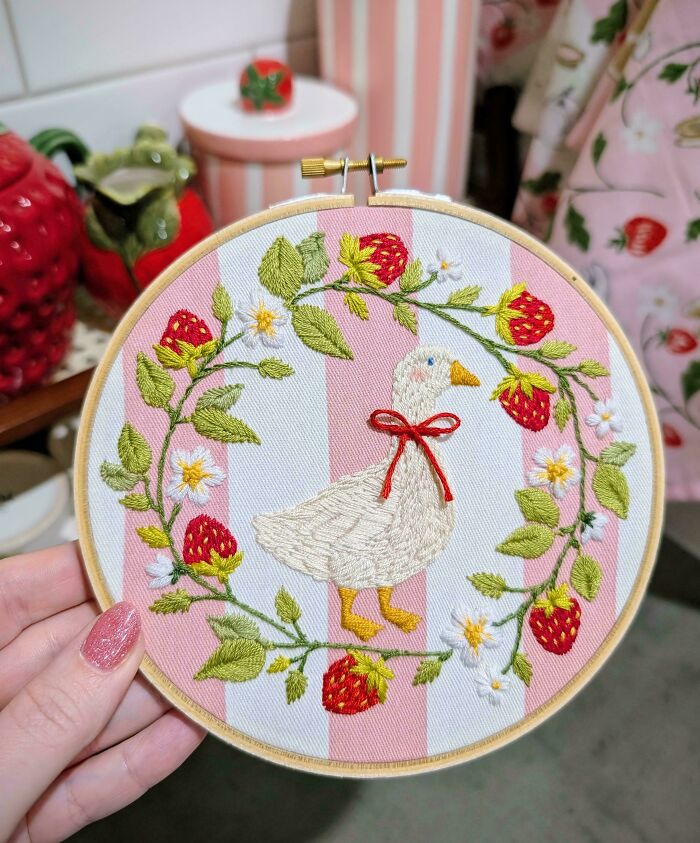 An adorable embroidered duck surrounded by strawberries in embroidery projects