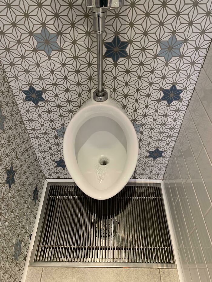 Urinal with floor grate for improved hygiene and drainage