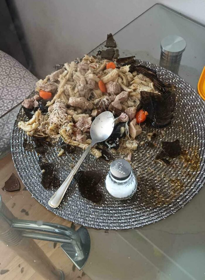 Burnt and spoiled food on a glass dining table with salt shaker