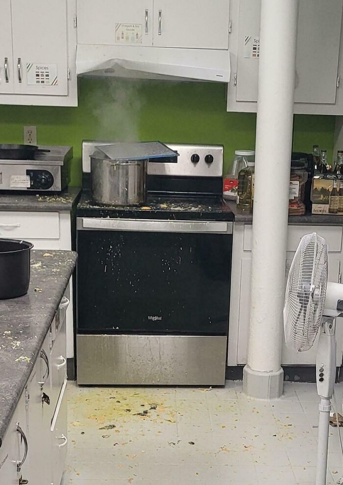Overflowing pot with spilled food and dirty kitchen floor