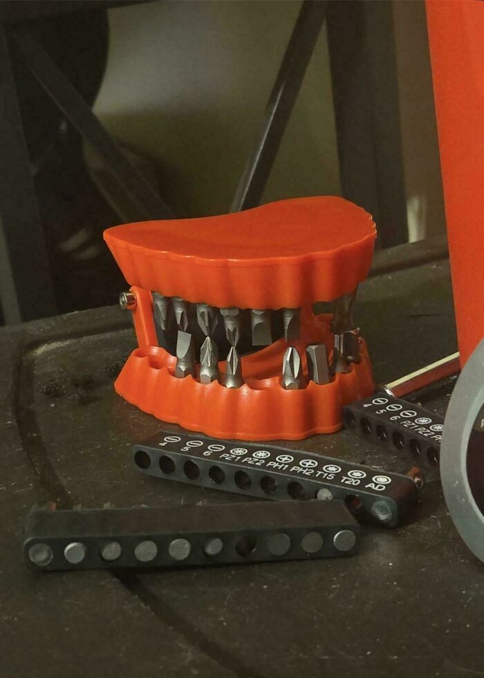 Red dental model tool organizer holding multiple screwdriver bits