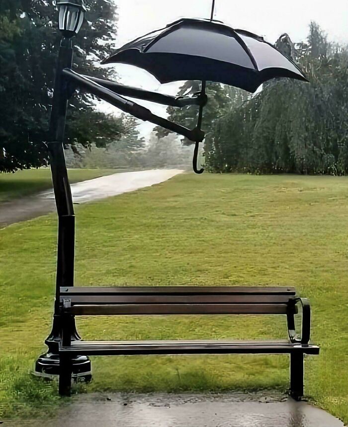 Park bench with umbrella holder providing sheltered seating in the rain